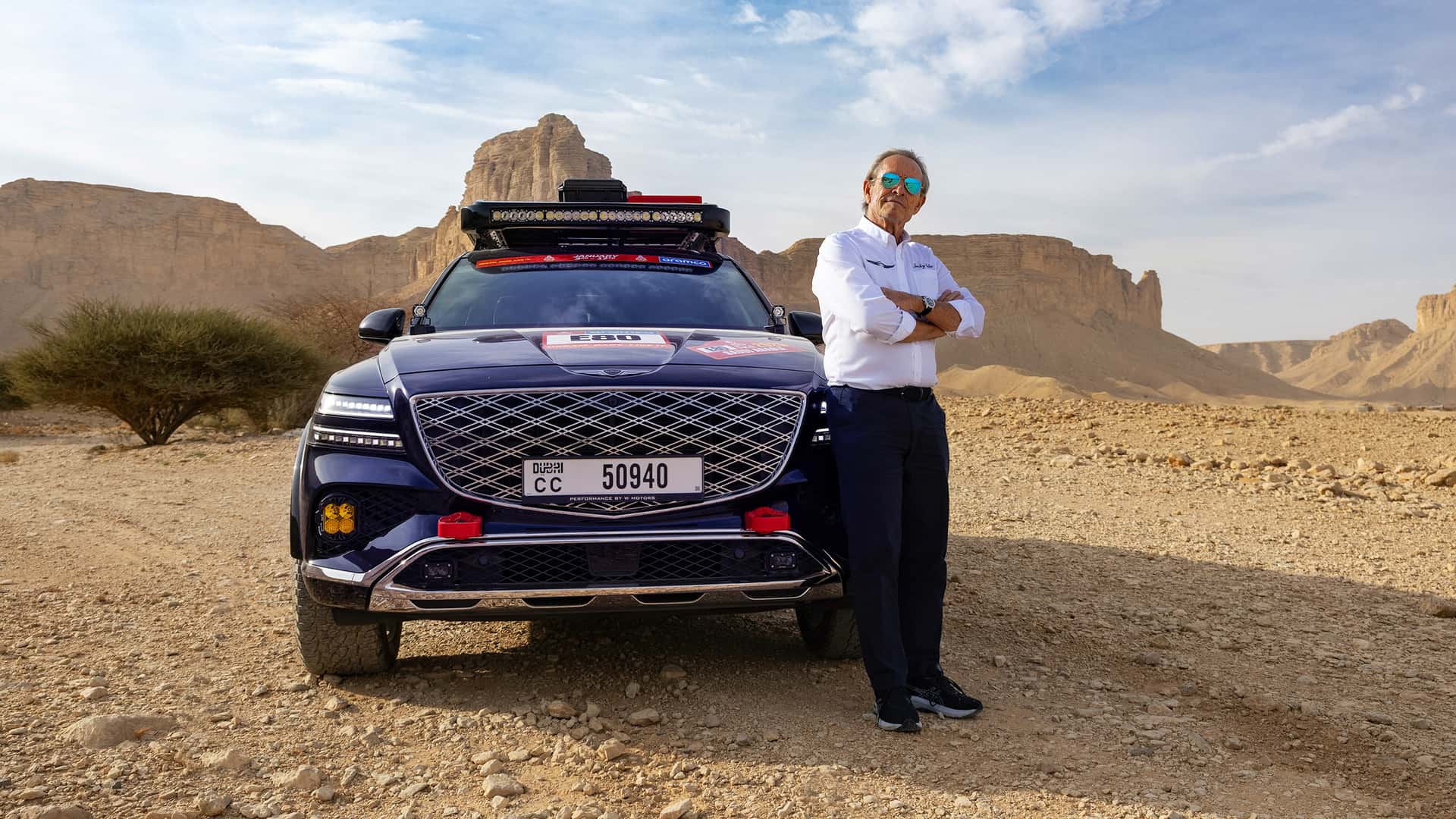 Джекі Ікс поруч із Genesis GV80 Desert Edition