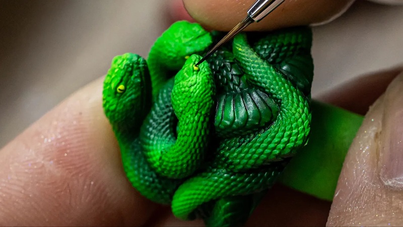 Vue détaillée du serpent à trois têtes en relief — la résine pleine bloque entièrement le rétroéclairage RGB.